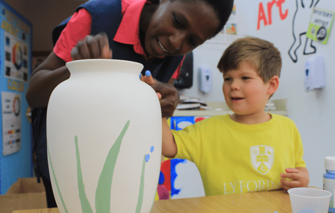 The Arts: teacher with student painting vase